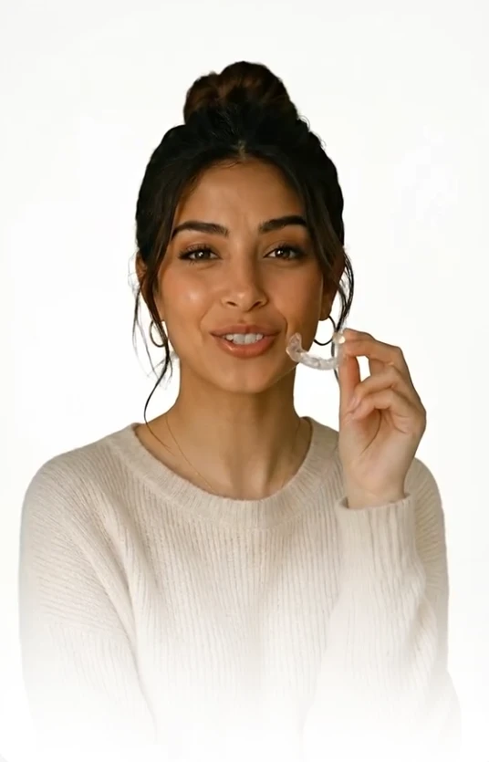 Woman smiling while wearing a clear aligner